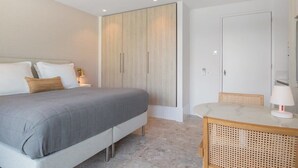 A bedroom with a bed, bedside table, lamp, and a wardrobe. - Studio near beach in Domburg | Summum Suites 2 (Domburg)