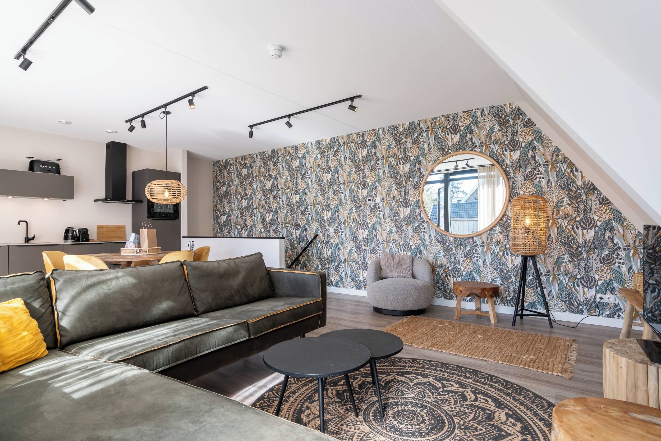 Un salon moderne avec un canapé, une table basse et un mur orné d’un motif.