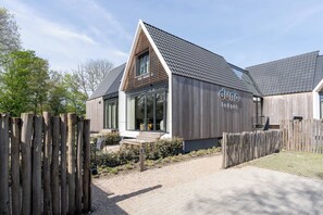 Un bâtiment moderne doté d’un toit en pente, d’une façade en bois et d  ’une enseigne indiquant « duno lodges ».