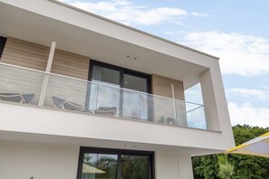 A modern two-story building with a balcony, large windows, and a flat roof. - Studio with AC in Domburg | Summum Suites 3 (Domburg)