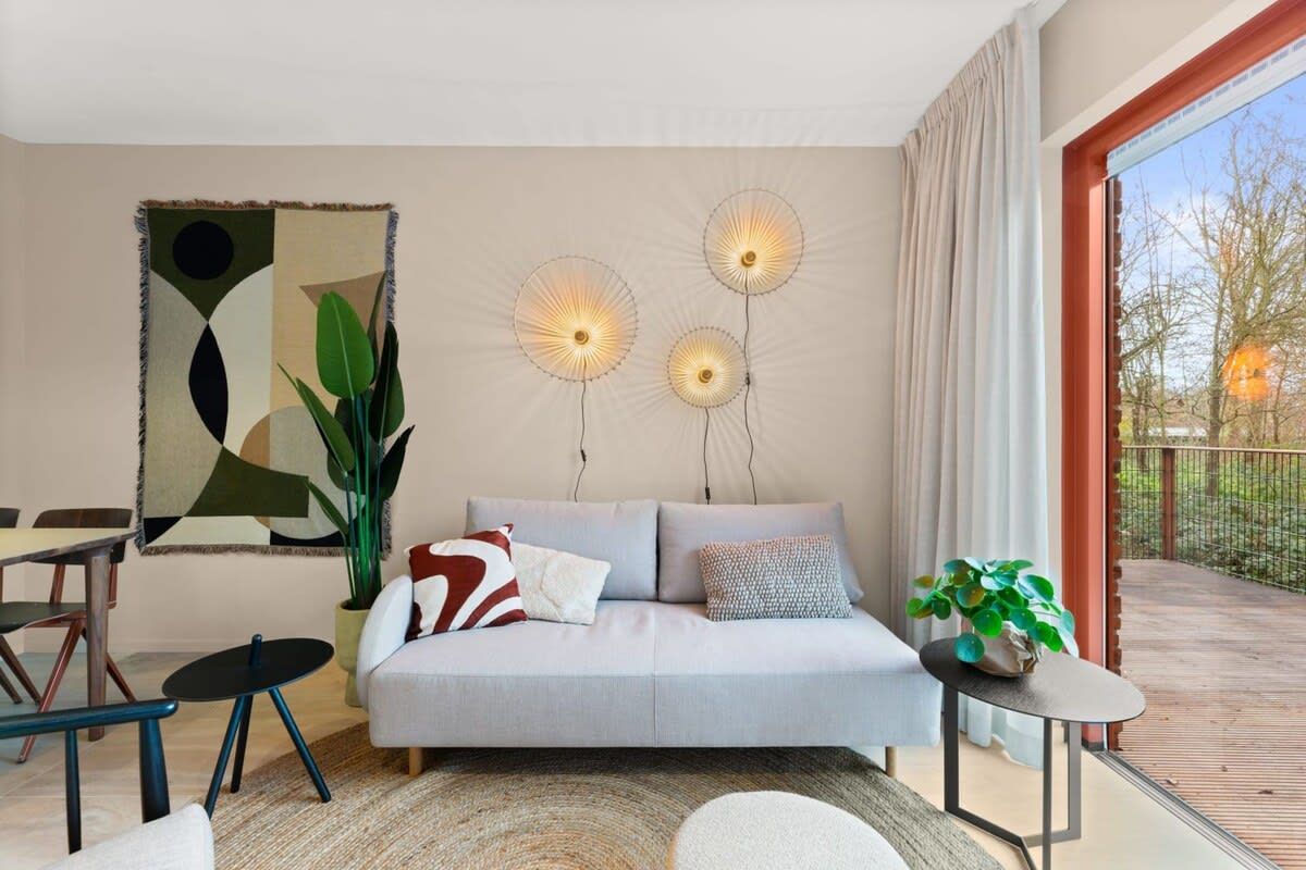 Una sala moderna con un sofá, una mesa de comedor y una planta en maceta.