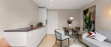 Una sala de estar moderna con sofá, una mesa de centro y un comedor con sillas y una mesa.