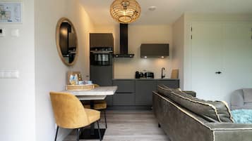 A compact living space with a dining area, kitchenette, and seating area.