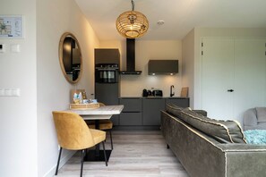 Un espace de vie compact comprenant un coin repas, une kitchenette et un coin salon.