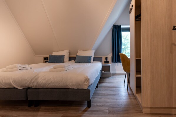 Une chambre à coucher comprenant un lit, des tables de chevet, une chaise et une armoire.