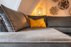 Un canapé moderne avec un revêtement en cuir et un seul coussin jaune.