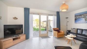 A modern living room with a TV, sofa, and a dining area.