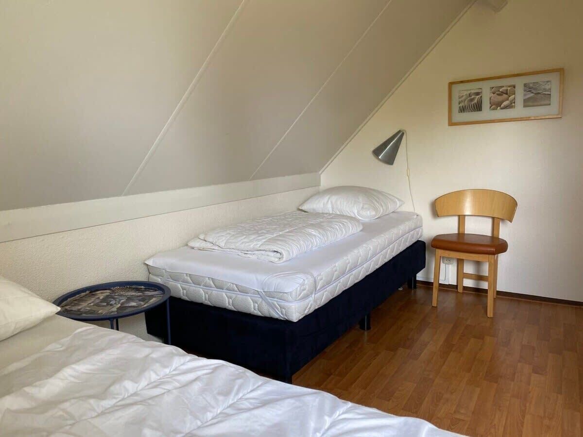 Un petit logement composé d’une seule pièce, comprenant un lit, une chaise et une petite table.