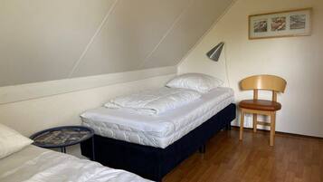 Un petit logement composé d’une seule pièce, comprenant un lit, une chaise et une petite table.