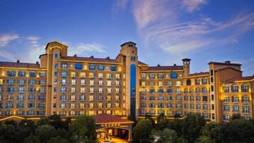 A large hotel with multiple floors, a central tower, and a well-lit facade.