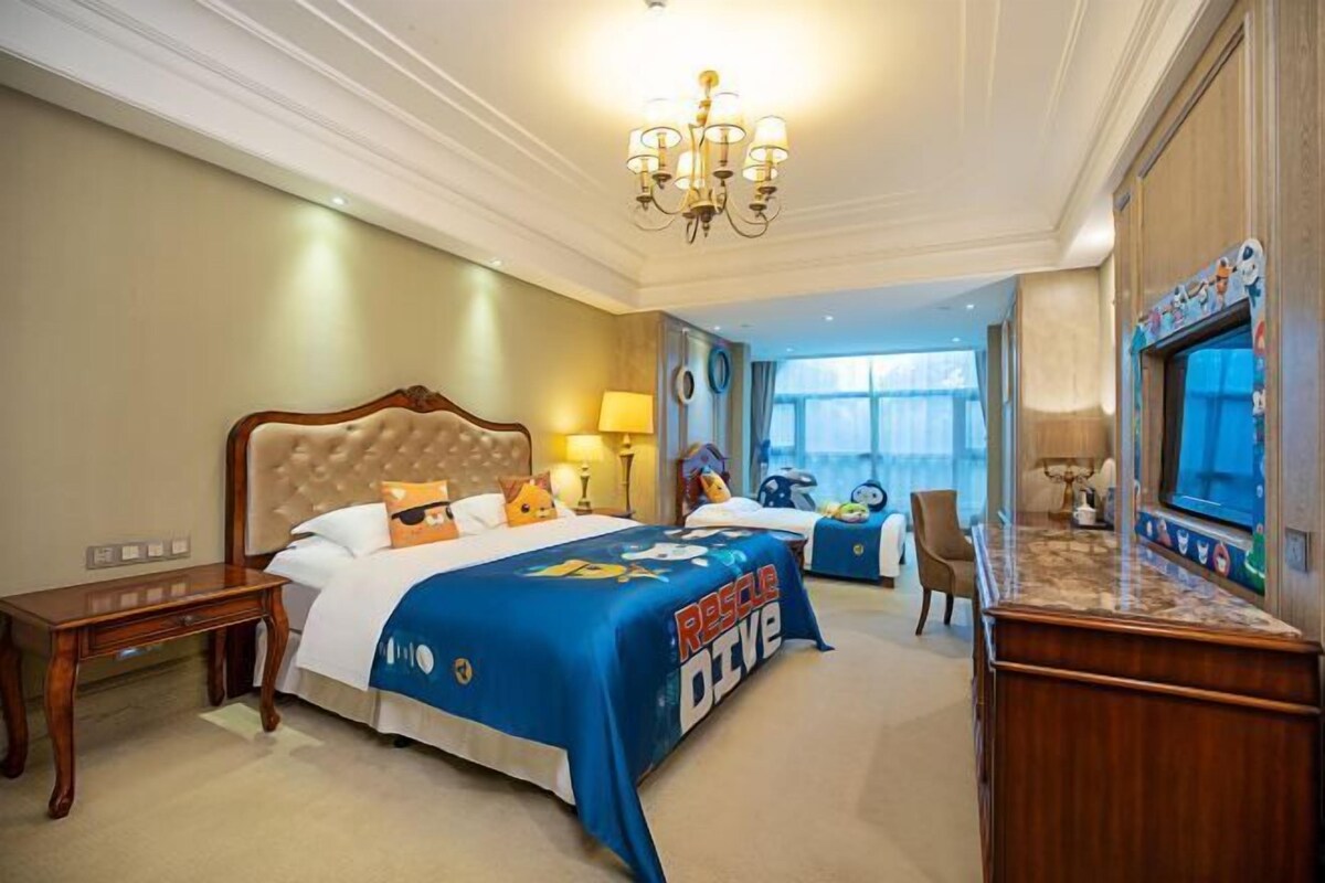 A hotel room with a large bed, a desk, and a television.