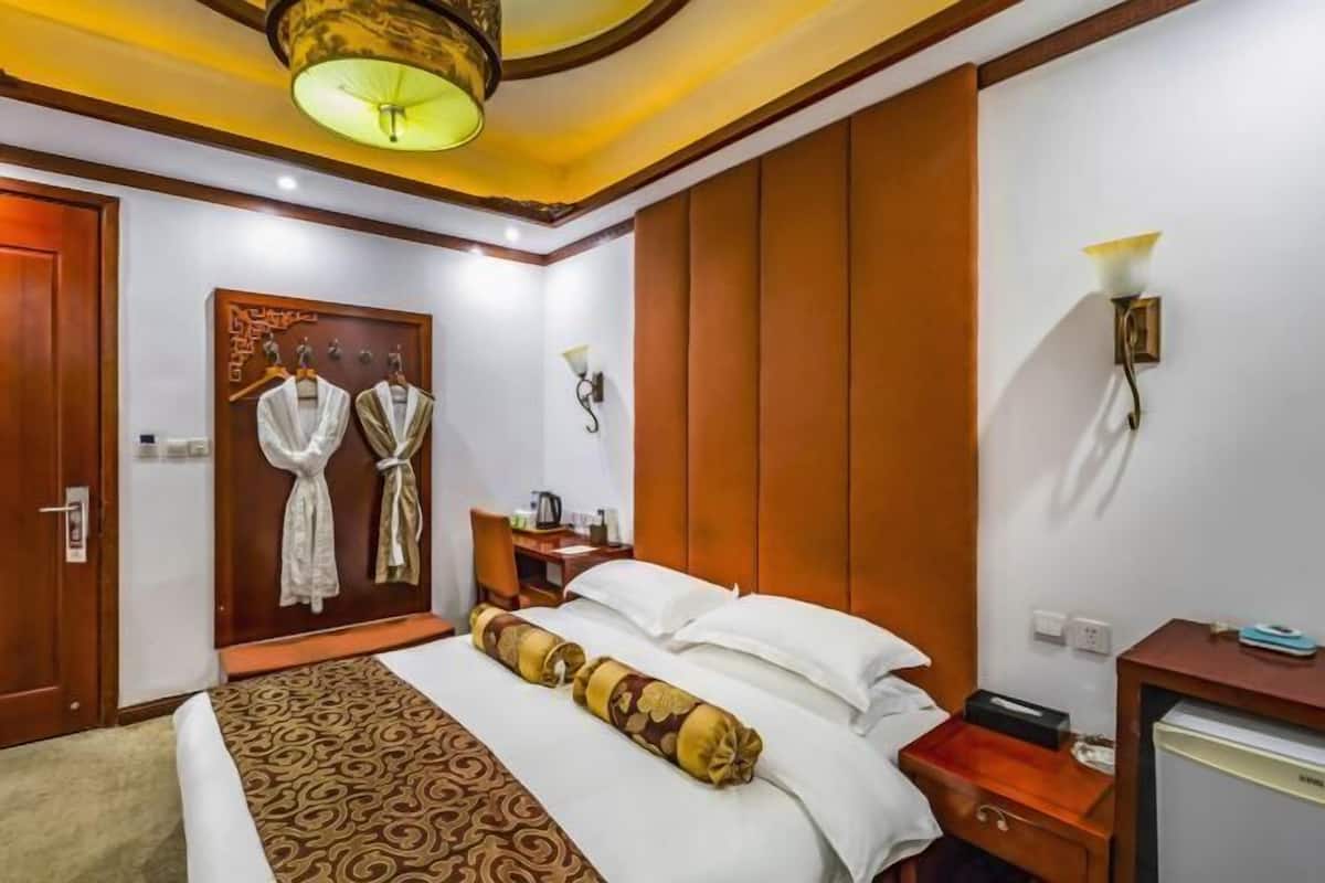 Habitación de hotel con cama, escritorio, armario y puerta.