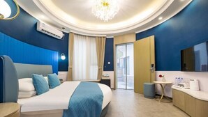 A modern hotel room with a large bed, a bedside table, a small table with a vase, and a TV mounted on the wall. - Yanling Bloom Hot Spring Hotel (Yanling)