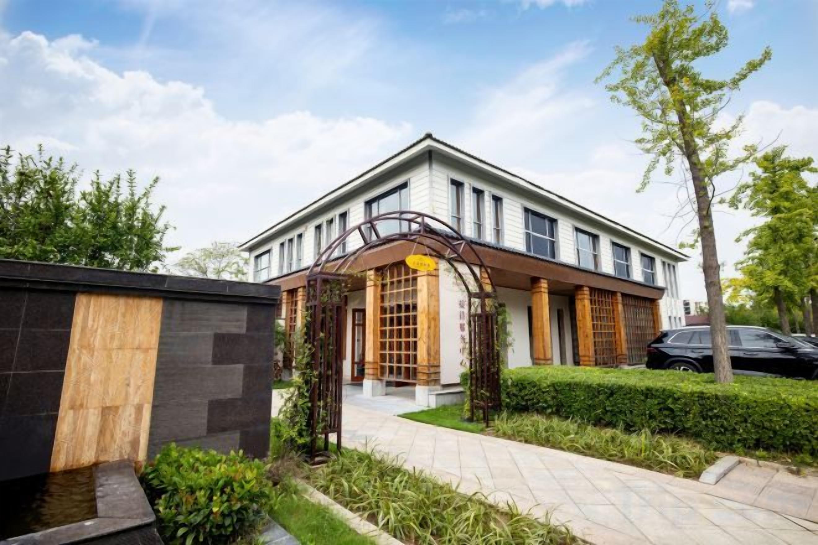 A modern two-story building with a covered entrance and a paved driveway.