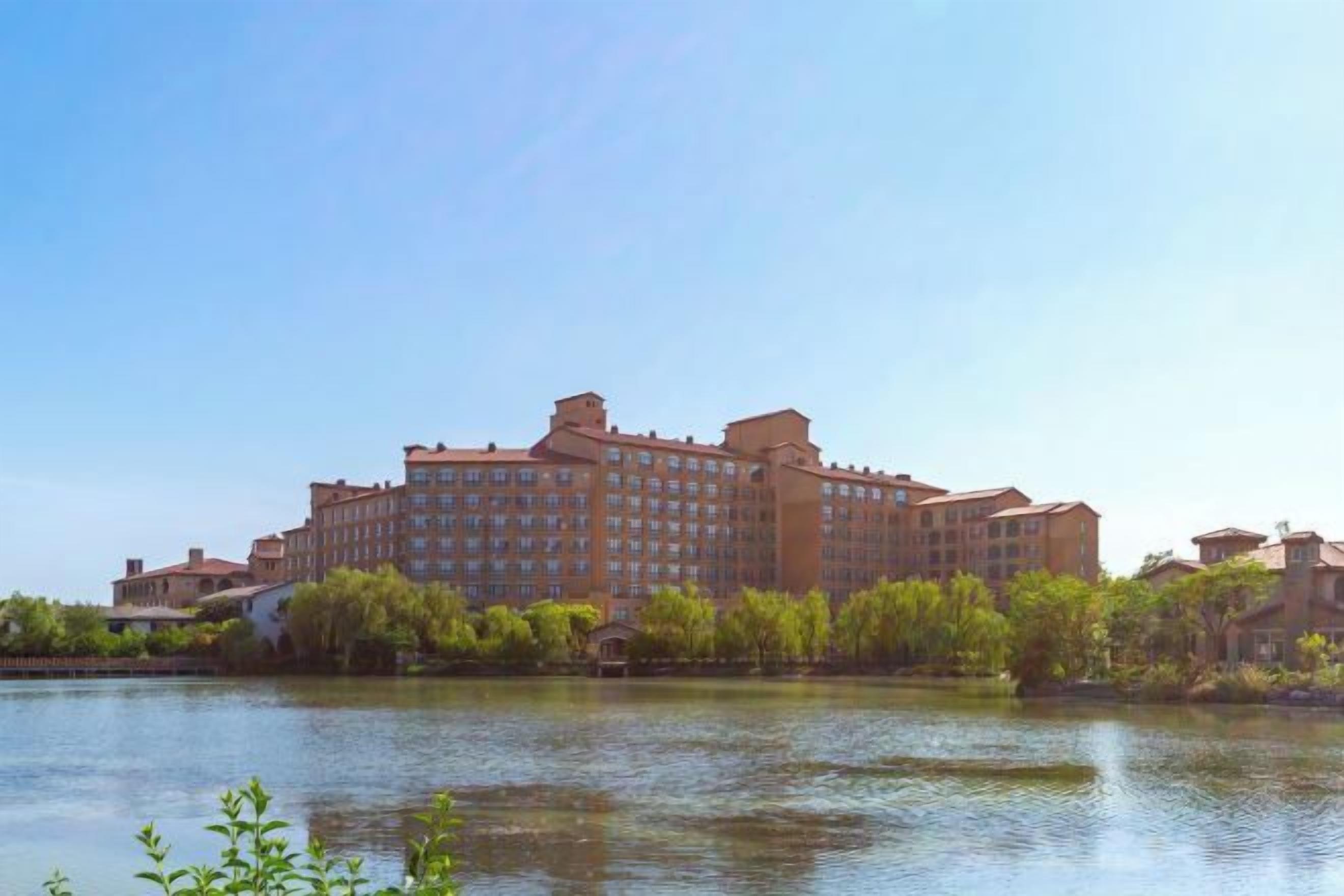 A large hotel with multiple floors, situated by a body of water.