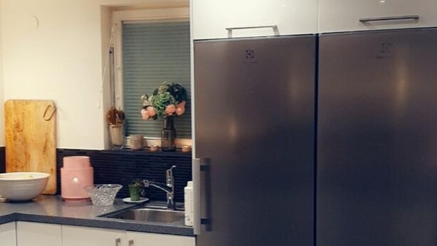 A modern kitchen with stainless steel appliances, white cabinetry, and a patterned rug. - Big House Close to Stockholm City (Hägersten)