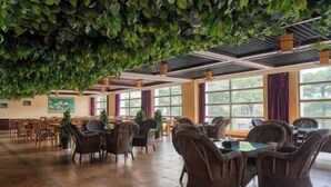 A spacious indoor area with wicker furniture and large windows. - Bianchui Hotel (Yingjiang)
