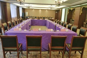 Una sala de conferencias con una larga mesa, sillas, placas de identificación y micrófonos.