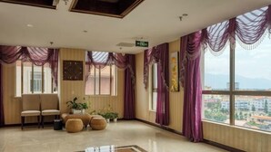 A hotel lobby with a large window, a reception desk, and seating area. - Bianchui Hotel (Yingjiang)