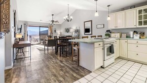 Una cocina amplia con una isla grande, armarios blancos y vistas al exterior.