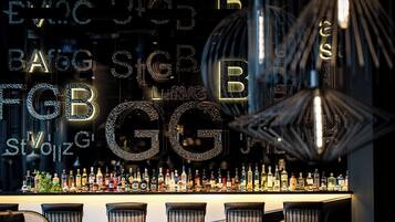 A bar area with a variety of liquor bottles and a decorative wall with illuminated letters.