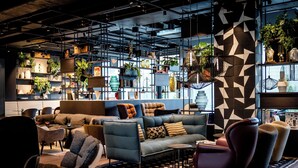 A modern lounge area with sofas, chairs, and a coffee table. - Motel One Karlsruhe (Karlsruhe)