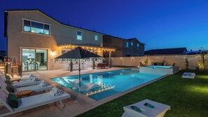 A backyard with a swimming pool, outdoor seating, and a covered patio area. - 2 Mi. To Coachella Festival - Pool, Spa, Gameroom (Coachella)