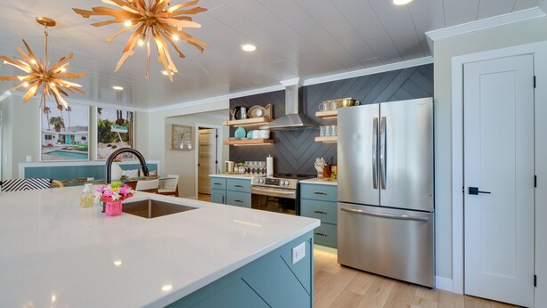A modern kitchen with a large island, stainless steel appliances, and pendant lighting. - Home Rental on Detroit Lake: Dock, Game Room! (Detroit Lakes)