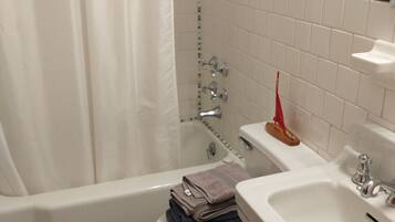 A bathroom with a bathtub, toilet, and sink.