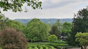 A landscaped garden with a winding path, neatly trimmed hedges, and a variety of trees. - Stylish 3 Bedroom Victorian Villa with hot tub (Lincoln)