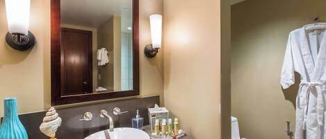 A bathroom with a large mirror, a sink, and a towel rack.