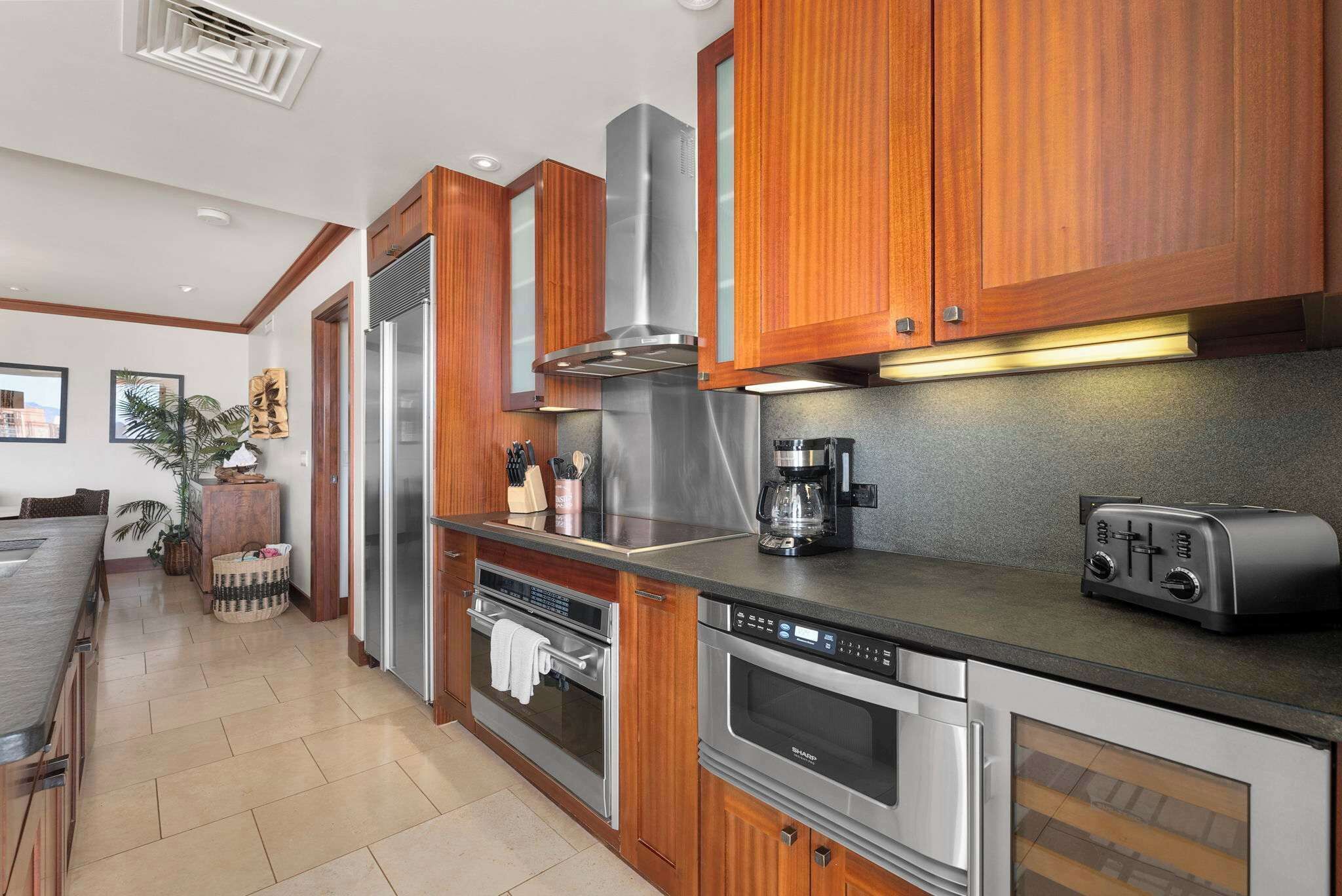Eine moderne Küche mit Holzausstattung, Edelstahlgeräten und einem eingebauten Backofen.