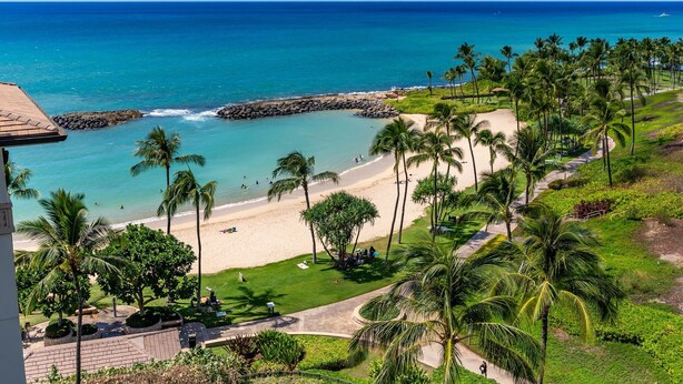 A beach view with palm trees, a sandy beach, and a clear blue ocean. - Hale Kai Ko Olina Villa w/ Ocean Views! (Kapolei)
