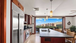 A modern kitchen with a large island, stainless steel appliances, and a view of a residential area. - Hale Kai Ko Olina Villa w/ Ocean Views! (Kapolei)