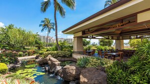 A resort with a pool, palm trees, and outdoor seating. - Hale Kai Ko Olina Villa w/ Ocean Views! (Kapolei)
