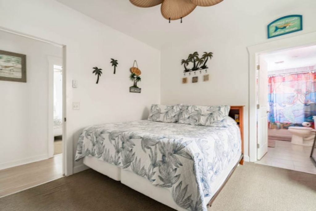 A bedroom with a bed, a door, and a wall with decorative items.