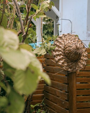 Un panier tressé posé sur un banc en bois, dans un jardin.