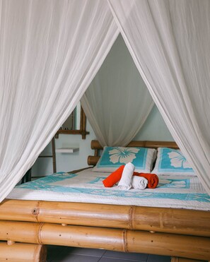 Un lit Ă baldaquin, avec une tĂȘte de lit en bois et une couvre-lit Ă motifs floraux.
