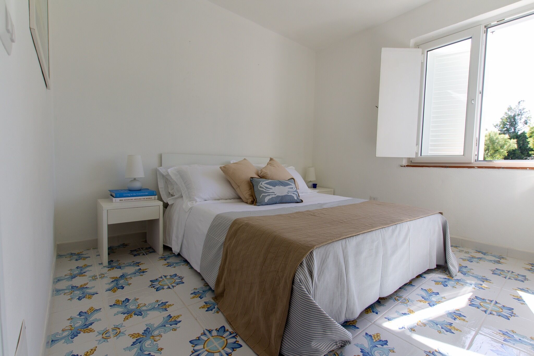 Une chambre à coucher avec un lit, une table de chevet et une fenêtre.