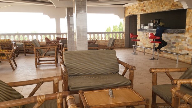 Un espace extérieur aménagé, abrité et doté de mobilier en osier et d’un comptoir de bar.