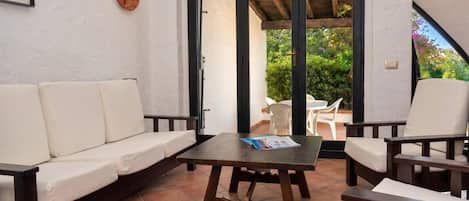 Une terrasse avec un canapé, des chaises et une table.