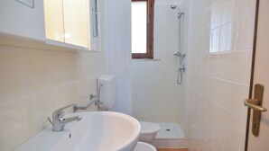 A bathroom with a sink, toilet, and shower.