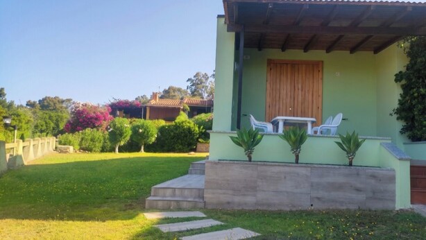 A house with a patio, a table, and chairs. - Villa Giorgia with garden - 50m from the Beach (Costa Rei)