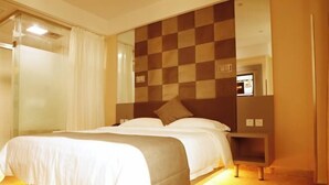 A hotel room with a large bed, a checkered headboard, a bedside table, and a mirror. - ELONG ruiyun Hotel (Yancheng International Exhibition Center) (Yancheng)