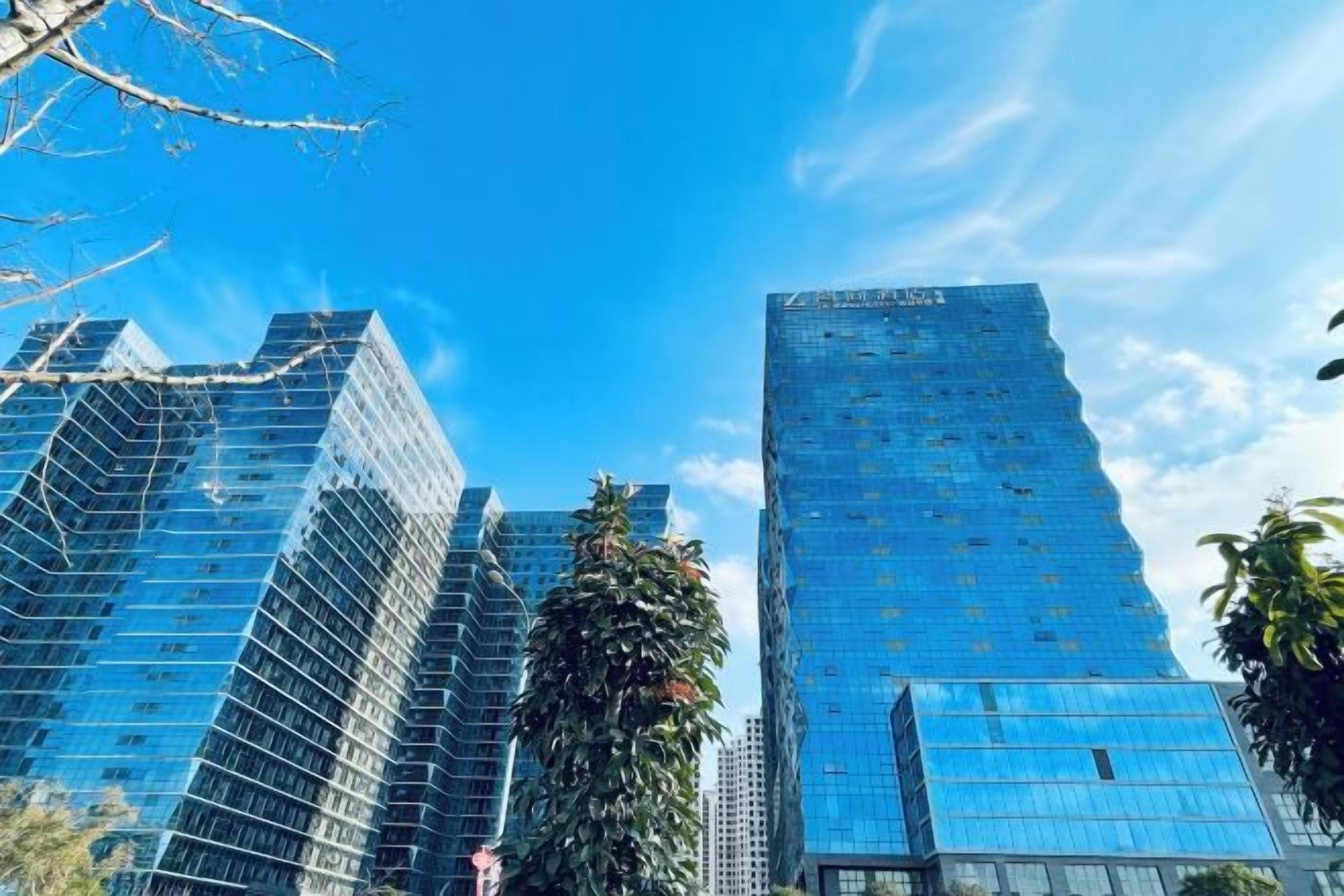 A high-rise building with a glass facade and a clear blue sky.