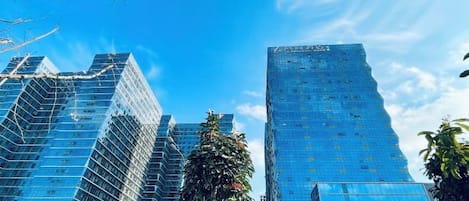 Un edificio alto con fachada de vidrio y un cielo azul despejado.