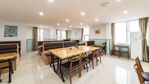 A spacious dining area with wooden tables and benches, large windows with curtains, and a clean, modern interior. - ELONG ruiyun Hotel (Yancheng International Exhibition Center) (Yancheng)