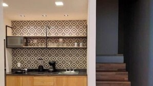 A modern kitchen with patterned backsplash, wooden cabinets, and a built-in stove.