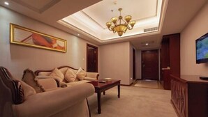 A living room with a sofa, a coffee table, a chandelier, a television, and a framed picture on the wall. - Vienna Hotel ( Hunan Zhangjiajie City Park ) (Zhangjiajie)