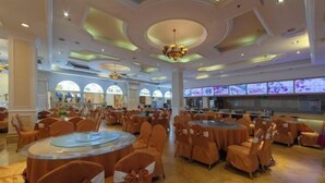 A spacious banquet hall with round tables and chairs, large windows, and a chandelier. - Vienna Hotel ( Hunan Zhangjiajie City Park ) (Zhangjiajie)